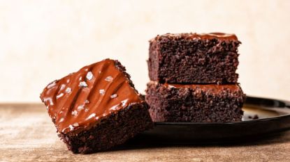 coca-cola cake recipe: slices of coca-cola cake stacked on plate with flaky salt