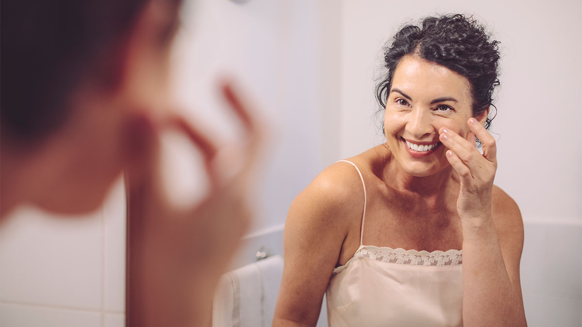 mature woman applying foundation after learning How to Choose a Foundation Shade