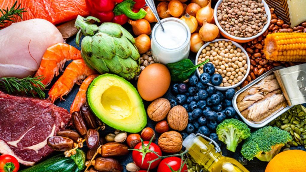 A table full of fresh produce (like avocado and tomatoes), lean protein (like chicken) and nuts and seeds, all of which can help you start losing weight on semaglutide