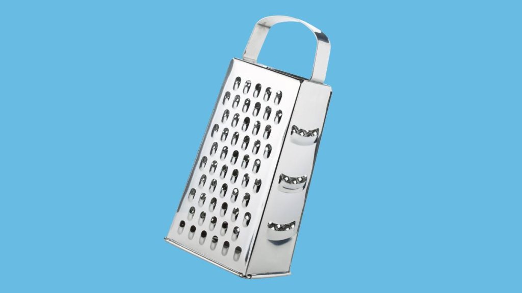 Metal grater with four different sides on blue background