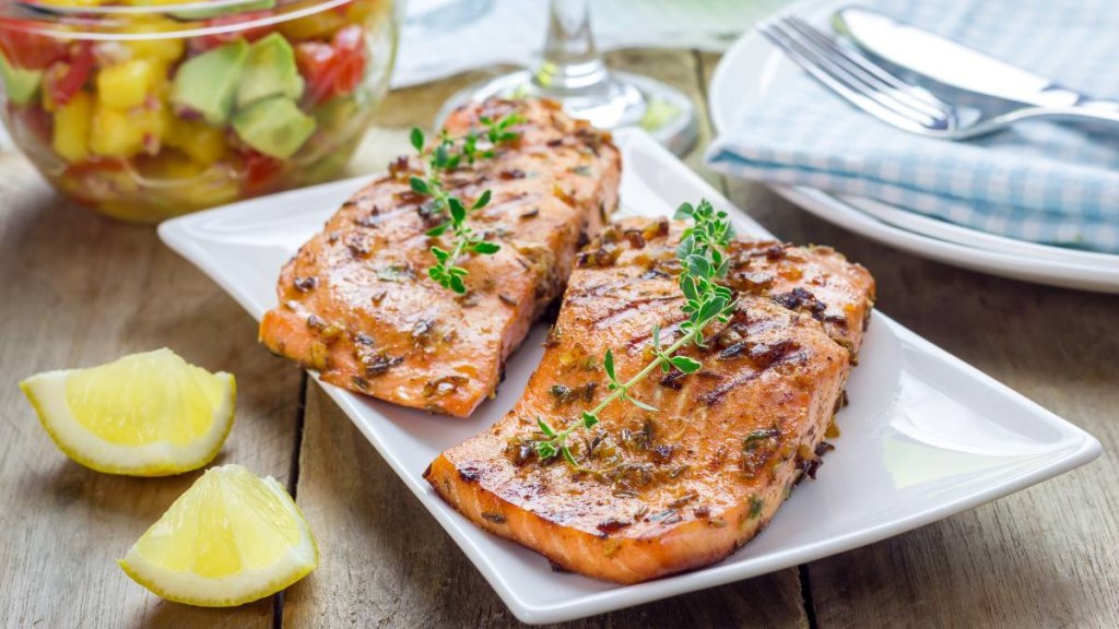 Spice grilled salmon and spicefruit with mango-avocado salsa on a white plate