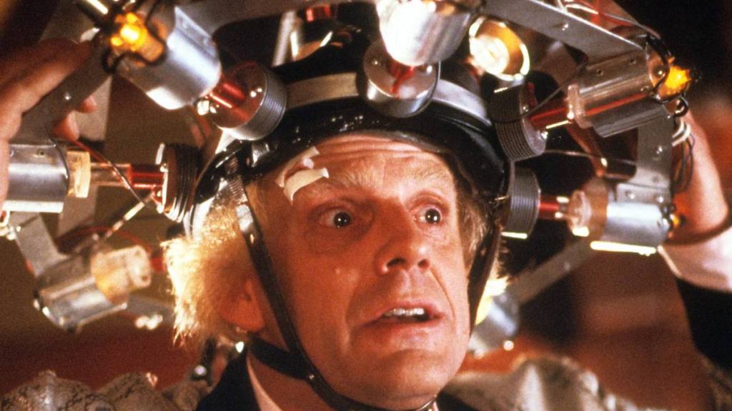 Christopher Lloyd wearing concoction on his head in a scene from the film