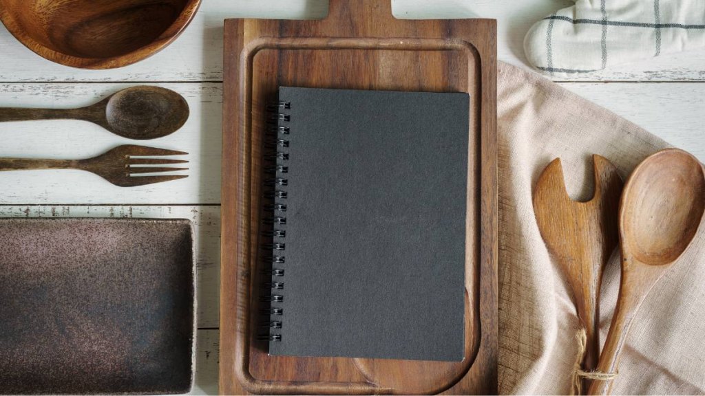 Gifts for Mother's Day: Open recipe book on green wooden table with copy space, Top view
