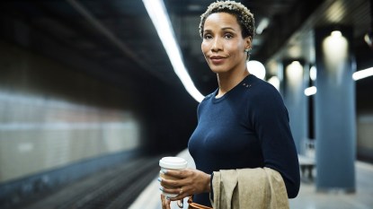 Woman waiting for train and holding coffee, how to be more patient