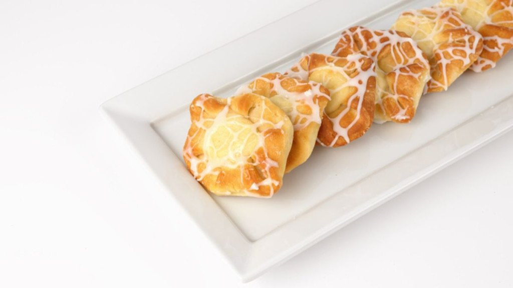 cheese danishes spread out on rectangular platter against white background