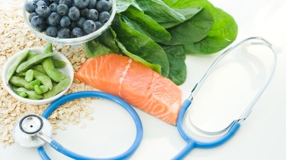 A stethoscope with heart-healthy foods such as: spinach, snap peas and blueberries