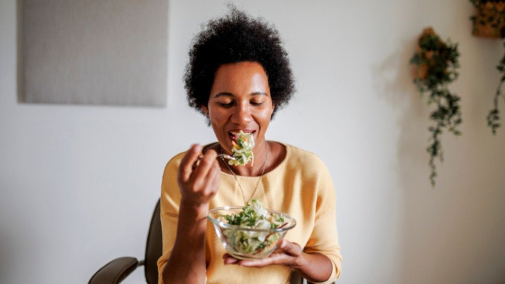 mature woman eating a bowl of salad
