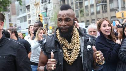 man with gold chains and thumbs up