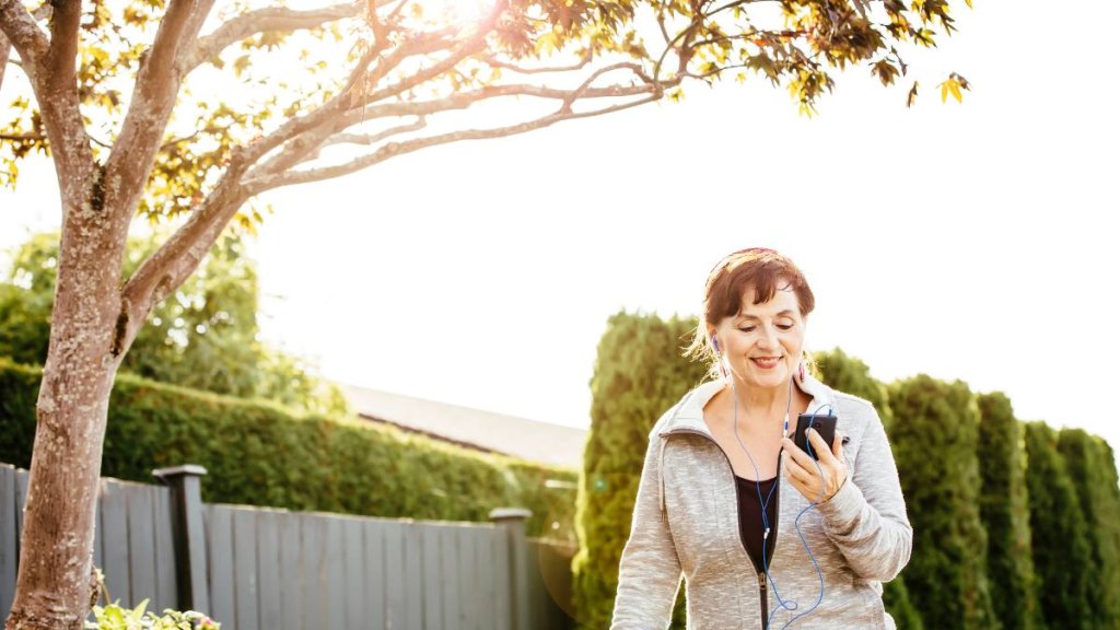 Woman walking while listening to music outdoors