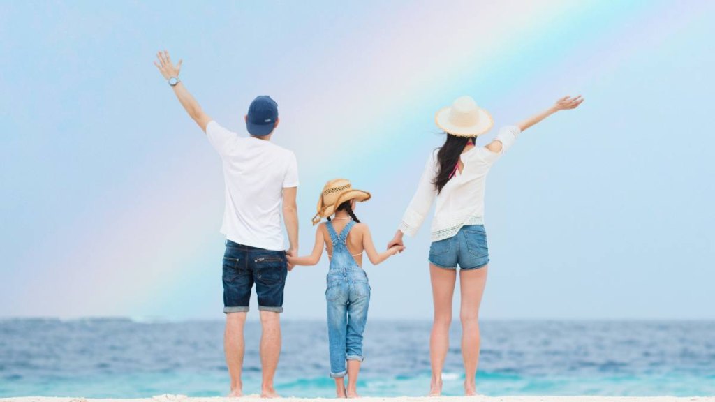 wives tales summer solstice: Family looking up at the sky on the rainbow beach