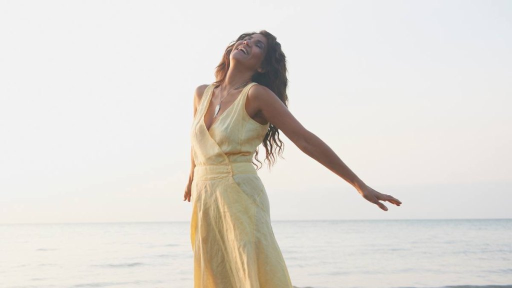 Hispanic woman standing on beach