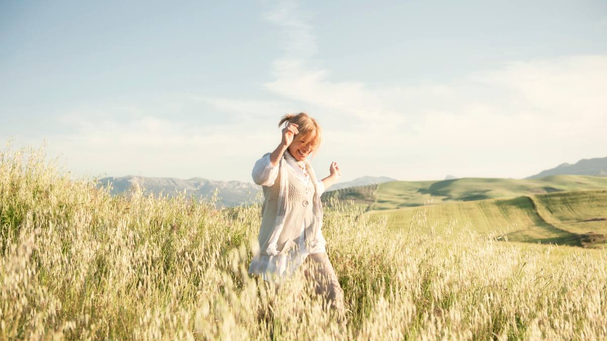 wives tales summer solstice: Woman running in the hills enjoying the springtime