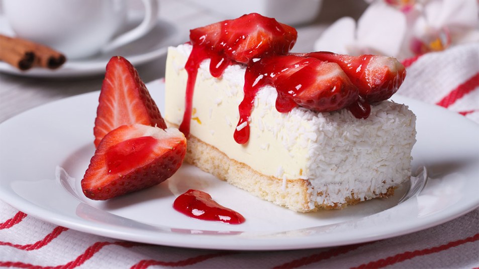 Slice of coconut cheesecake with berries on top