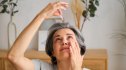 A woman using eye drops as part of her dry eye syndrome self-care plan