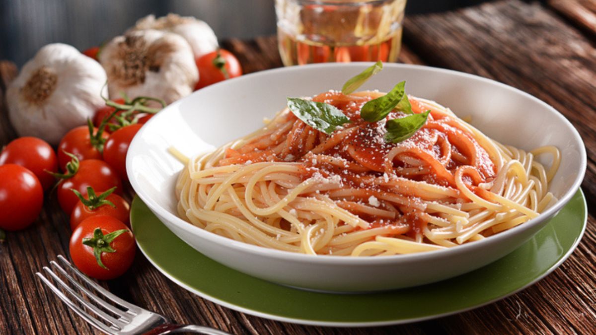 grated tomato pasta in bowl with fresh tomatoes and garlic