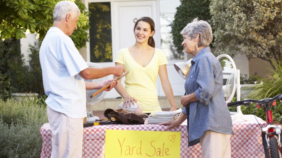 Couple talking to woman at yard sale