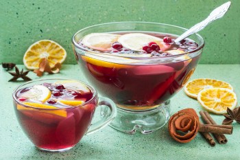 Punch bowl filled with red punch and citrus slices