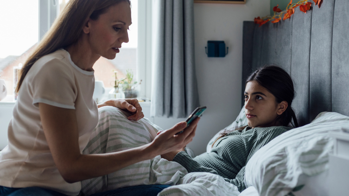 Mother looks at daughter's phone with concerned look