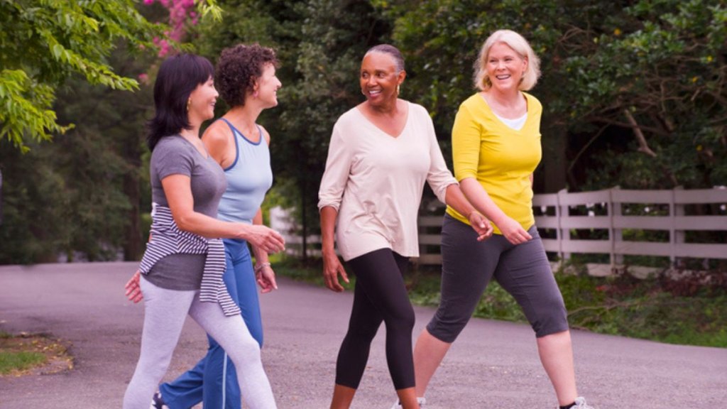 A group of mature women walking outdoors while smiling and laughing