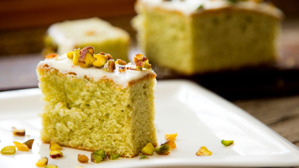 zucchini bar on plate with frosting and nuts