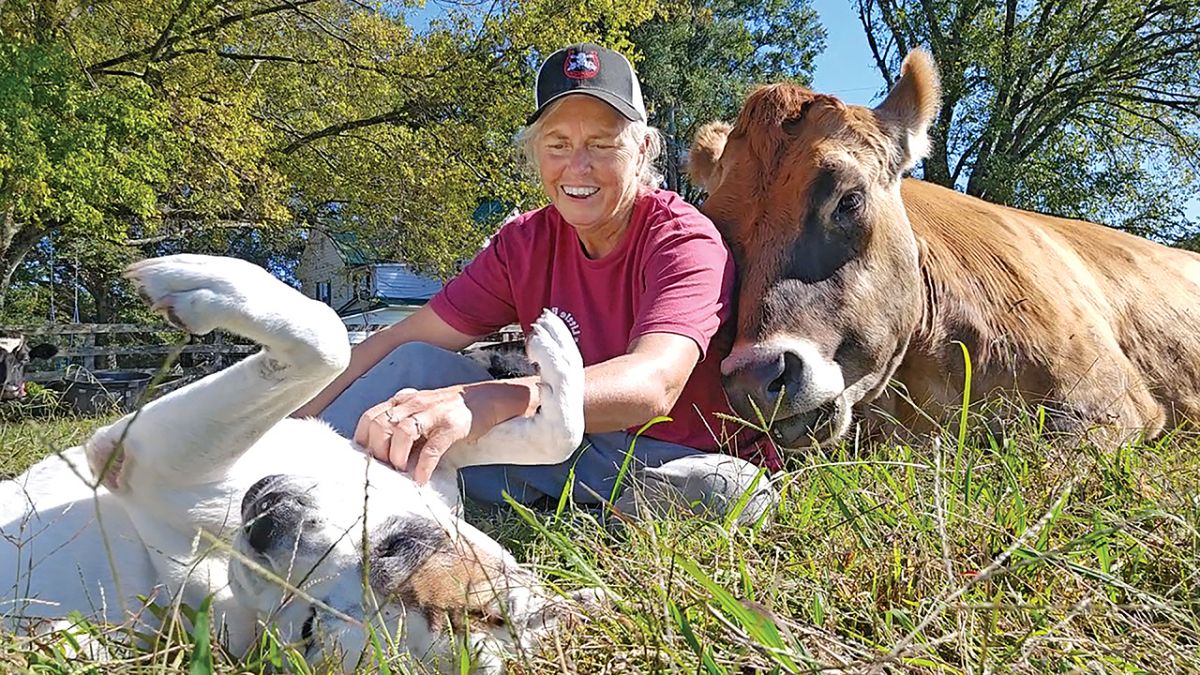 Woman with dog and cow.