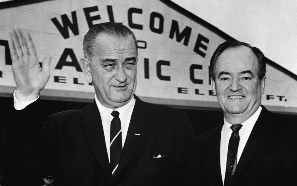 President Johnson and Hubert Humphrey stand together at the airport in Atlantic City. They are returning from the Democratic convention, where they were nominated as presidential and vice presidential candidates, and en route to the LBJ ranch in Texas.