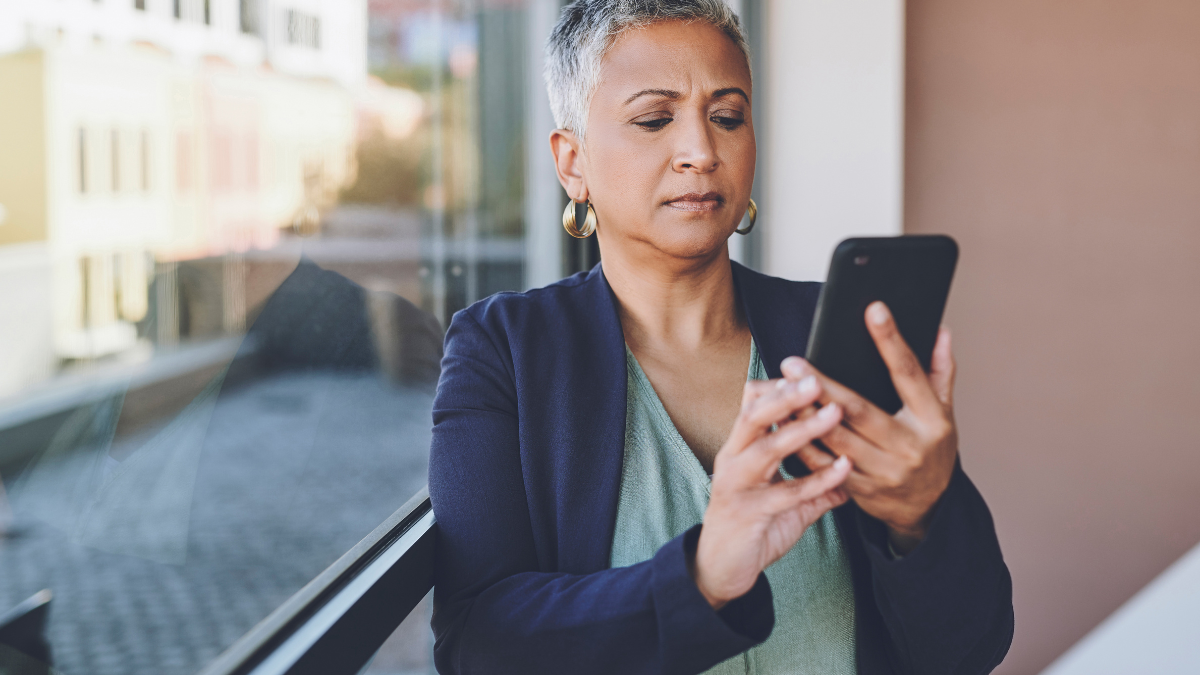 Mature woman looks at smartphone