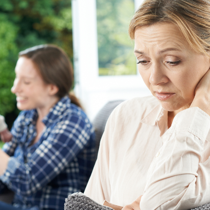 woman longing to be a mother herself, looks forlorn, as her friend plays with her baby