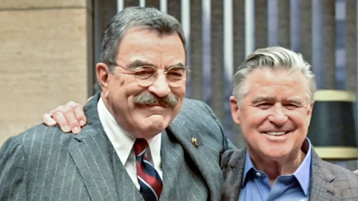 Actors Tom Selleck and Treat Williams with their arms around each other's shoulders on the set of Blue Bloods