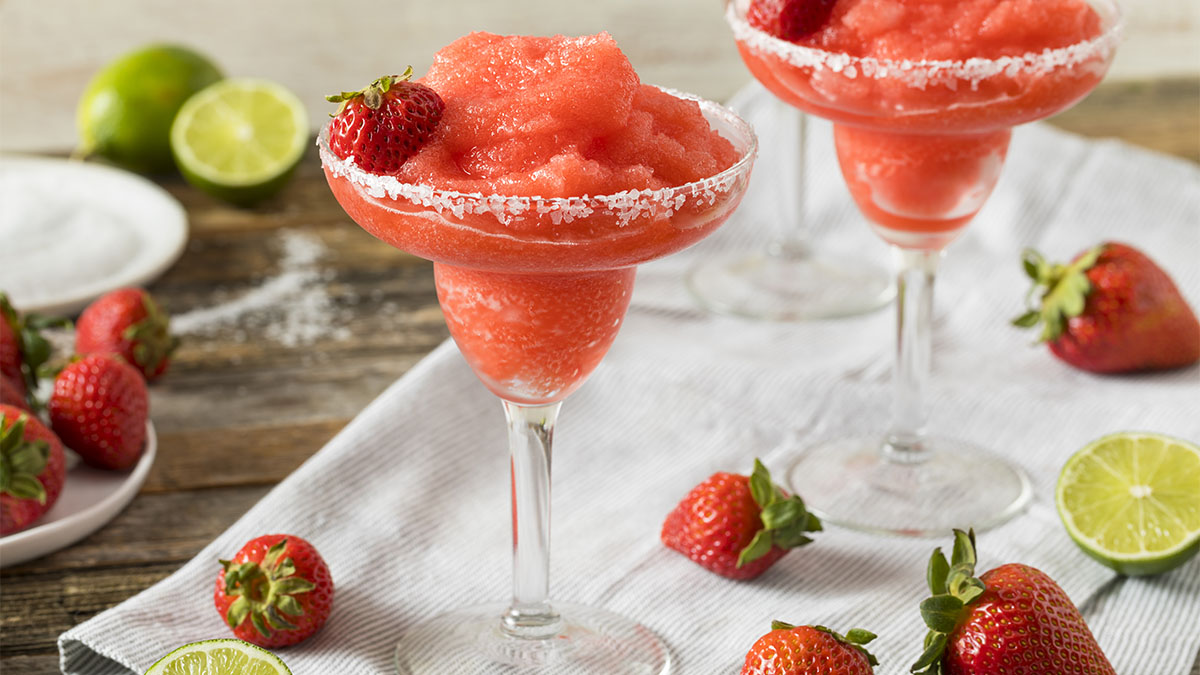 Strawberry peach daiquiri made with rum in sugar-rimmed glass