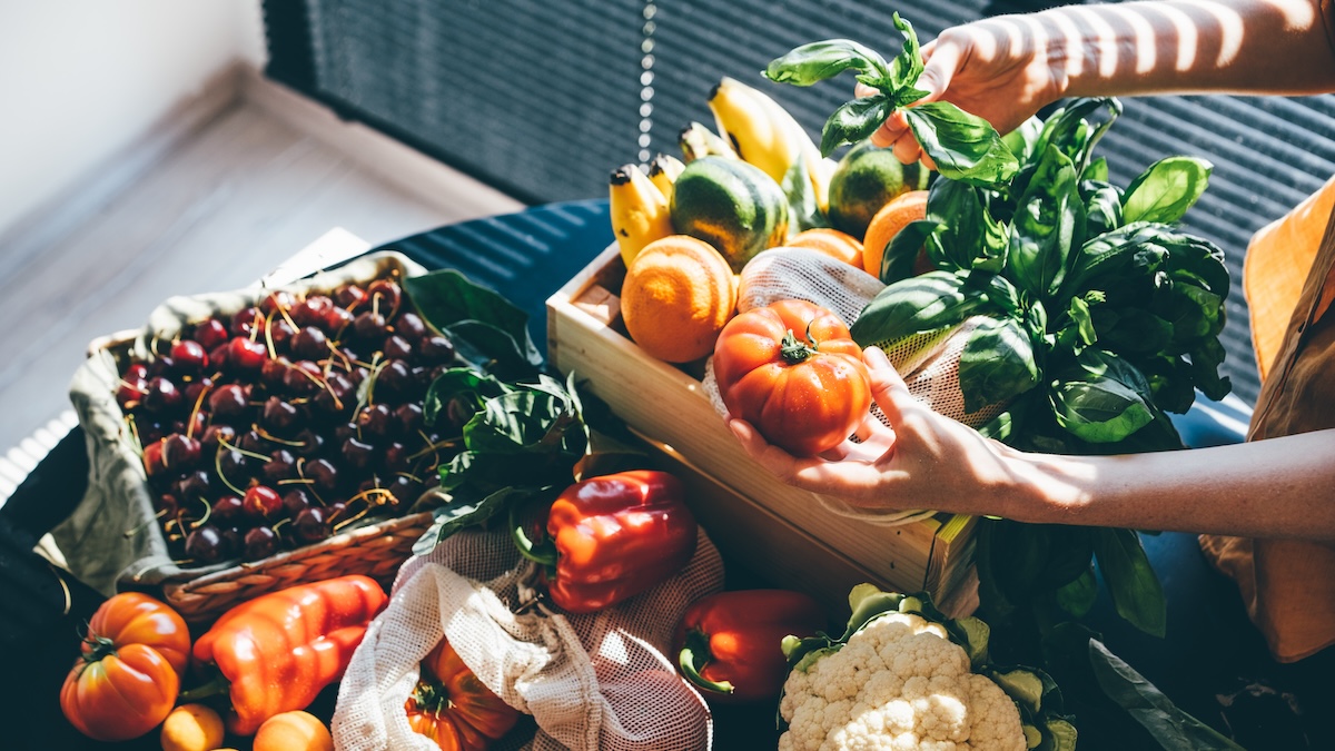 A woman unpacks fruits and vegetables at home after shopping at a local farmers' market.