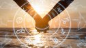 Cropped image of couple holding hands at beach during sunset