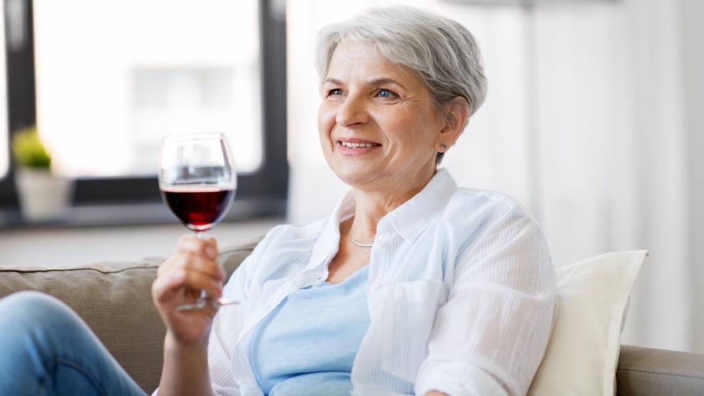 Woman drinking red wine to help heal fatty liver and lose weight