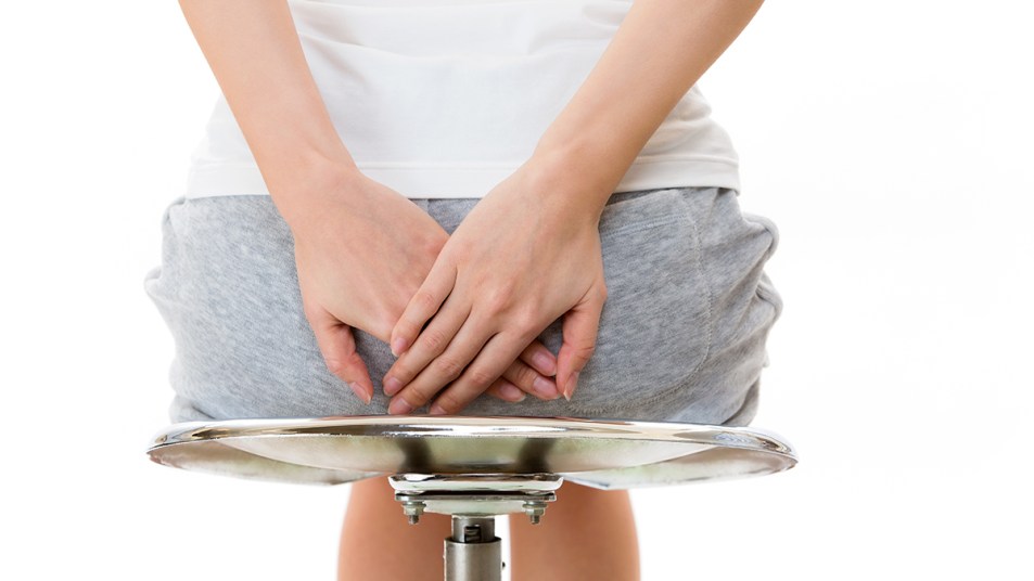 A woman holding her bottom because of the discomfort caused by hemorrhoids