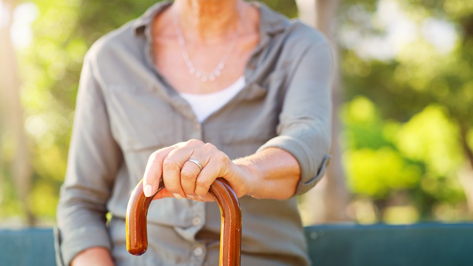 A woman holding onto a walking cane