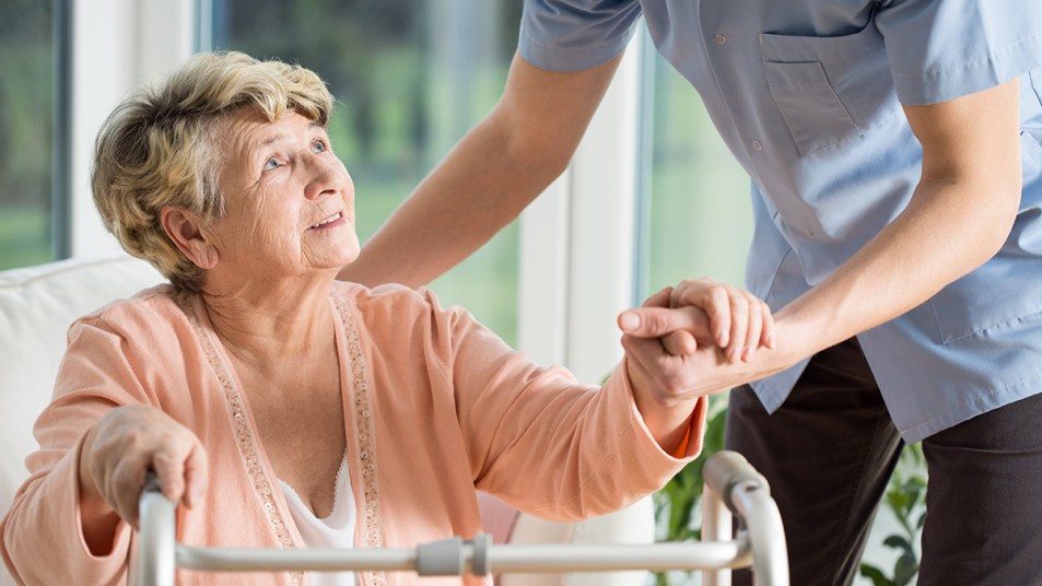 Woman with a walker in a nursing home looking concerned