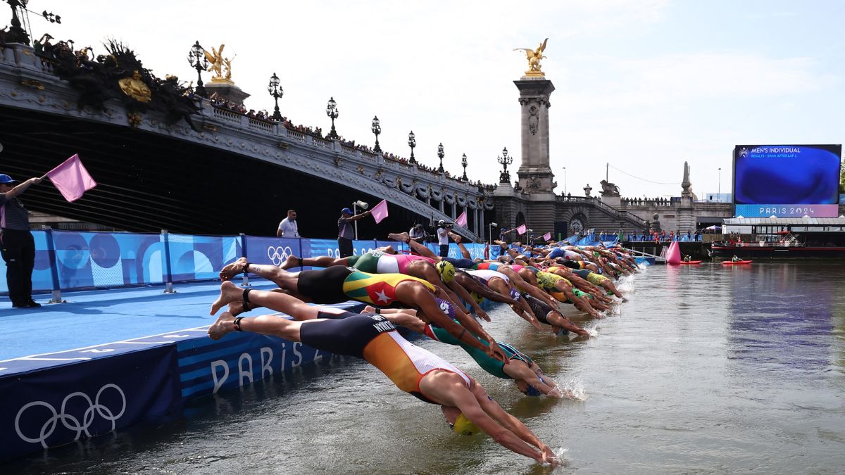 Athletes dive into the Seine river to start the swimming stage of the men's individual triathlon at the Paris 2024 Olympic Games in central Paris on July 31, 2024