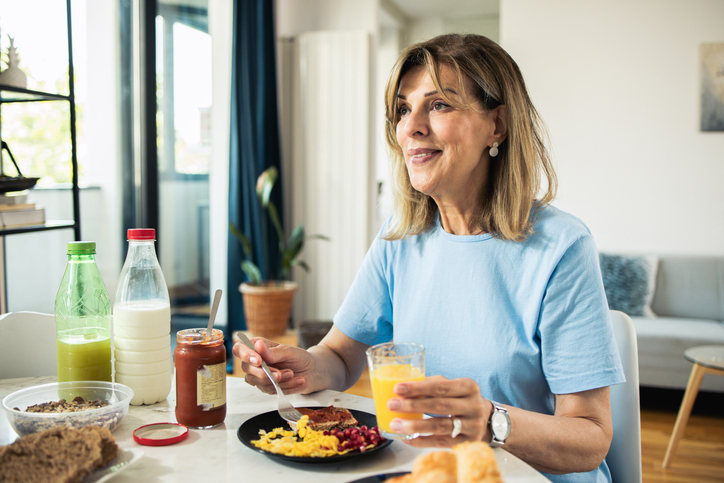 Happy mature woman planning on walking after eating her breakfast