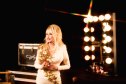 Dolly Parton holding one of the lipsticks from the Dolly Parton lipstick line