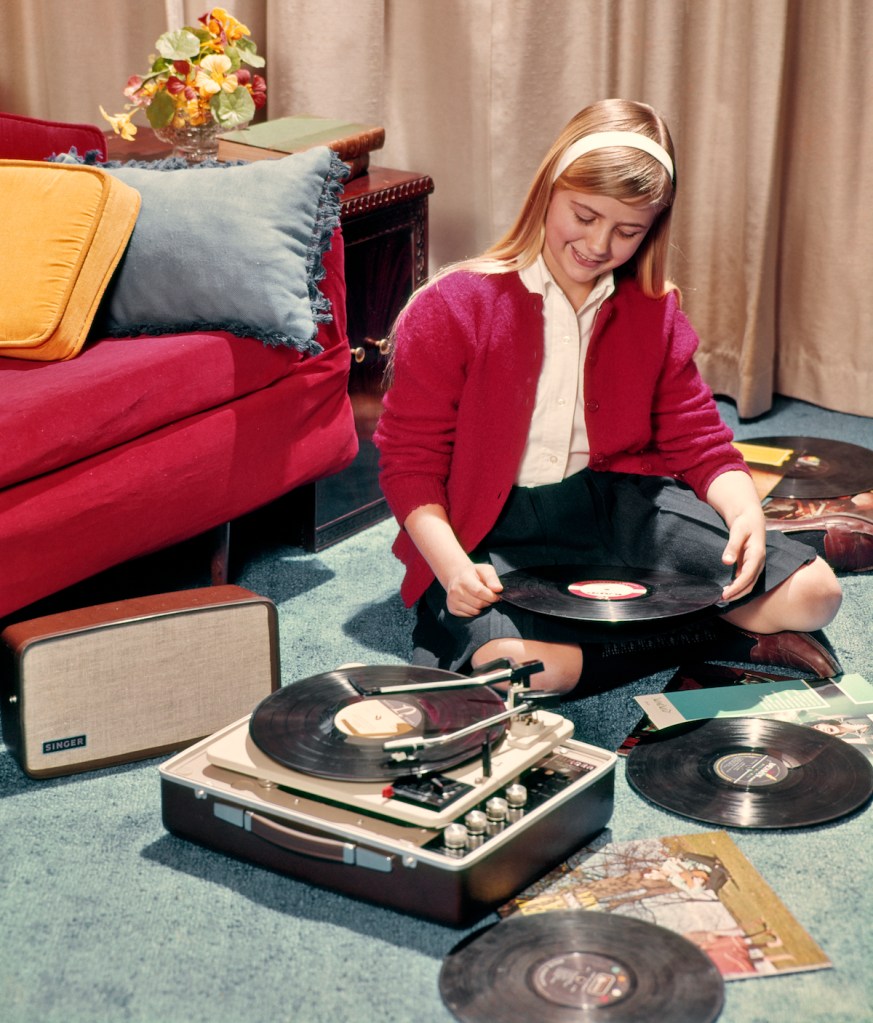 A teen girl with record player in the '60s