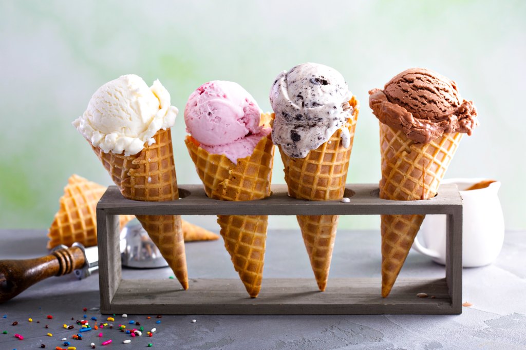 Variety of ice cream scoops in cones with chocolate, vanilla and strawberry