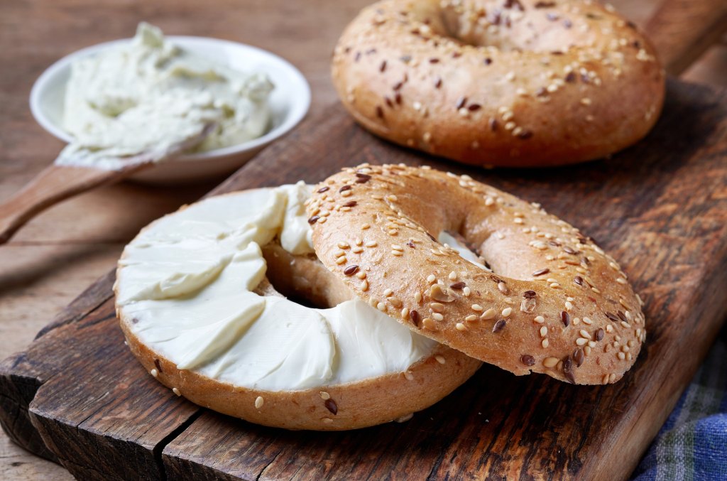 bagels with cream cheese on wooden board