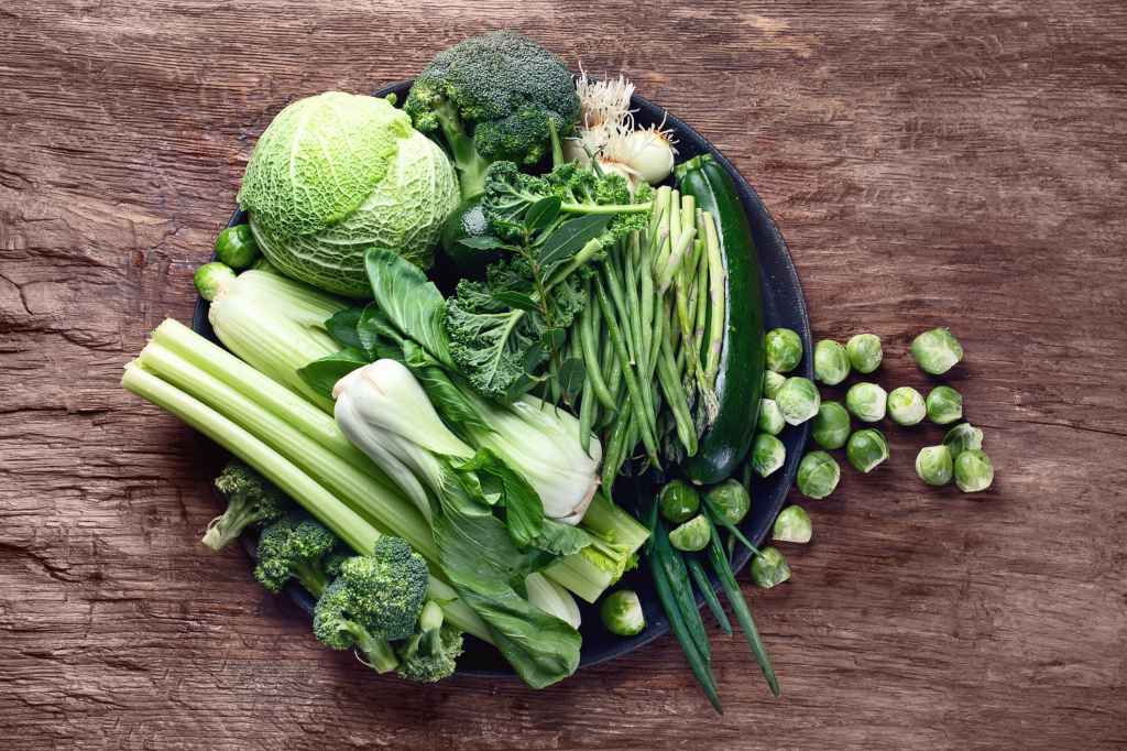 Fresh green vegetables commonly grown with dcpa weedkiller on wooden table