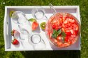 hwachae "korean fruit punch" in bowl with glasses on serving tray