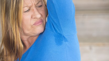 Woman looking at her armpit wondering about her menopause body odor
