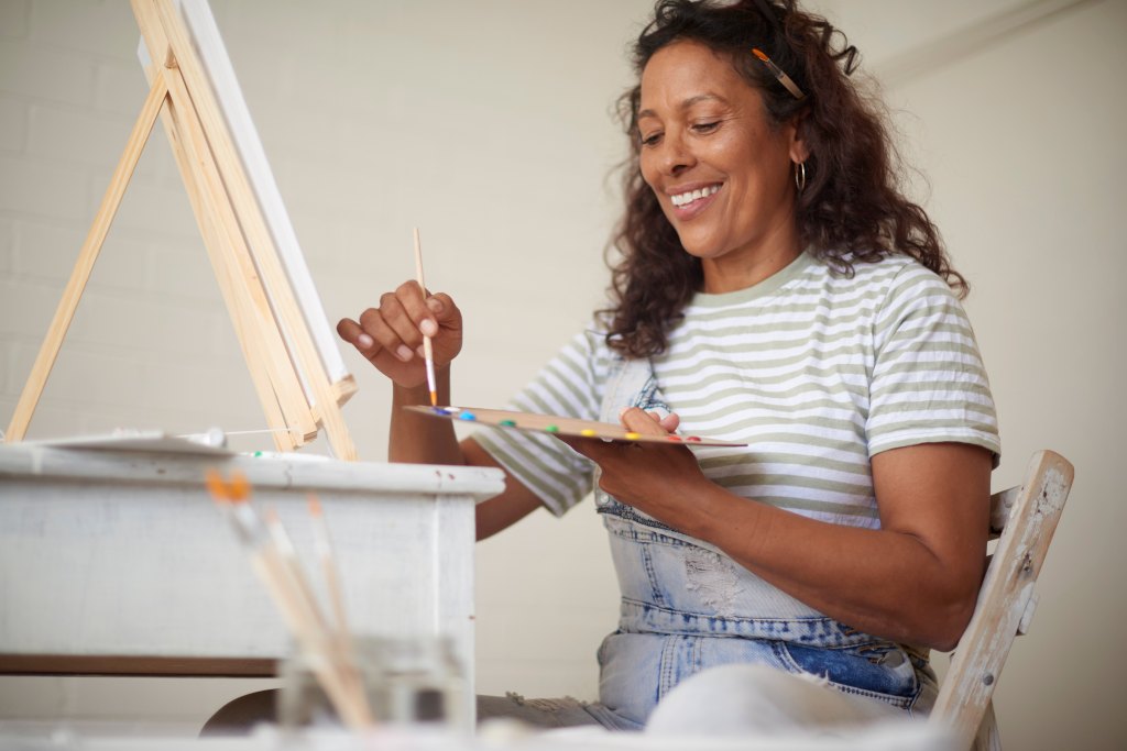 woman smiling and painting