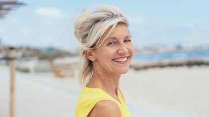 Woman smiling after soothing and preventing a sunburned scalp