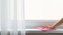 woman's hand cleaning a window sill