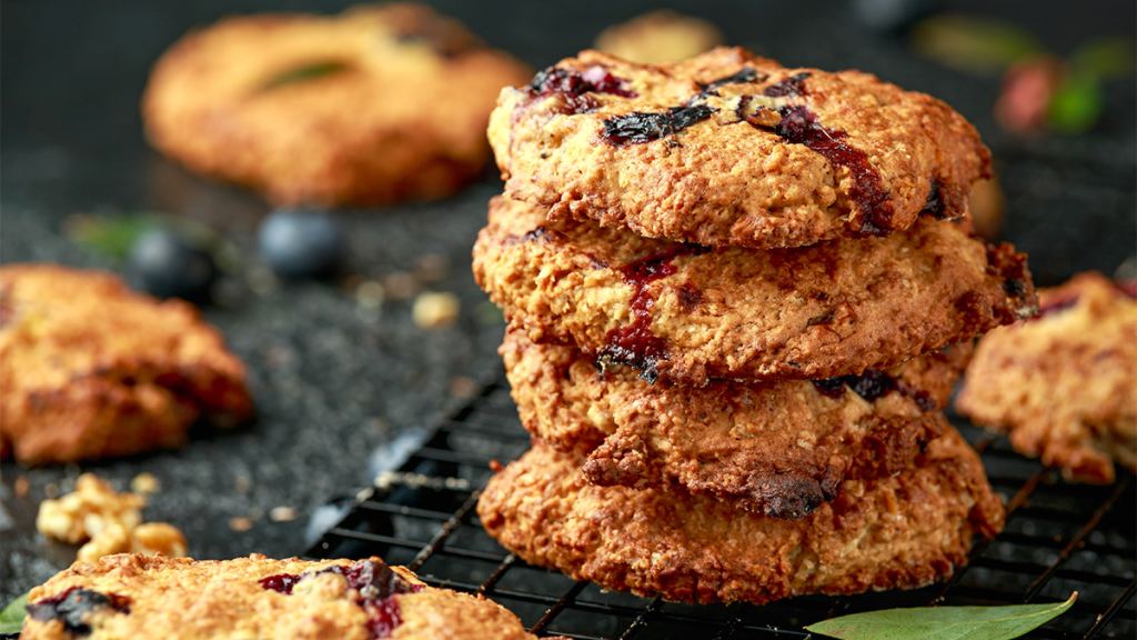 A batch of blueberry white chocolate oatmeal cookies cooling on a wire rack