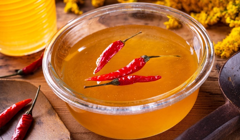 Chili peppers in a jar of honey used to make spicy honey